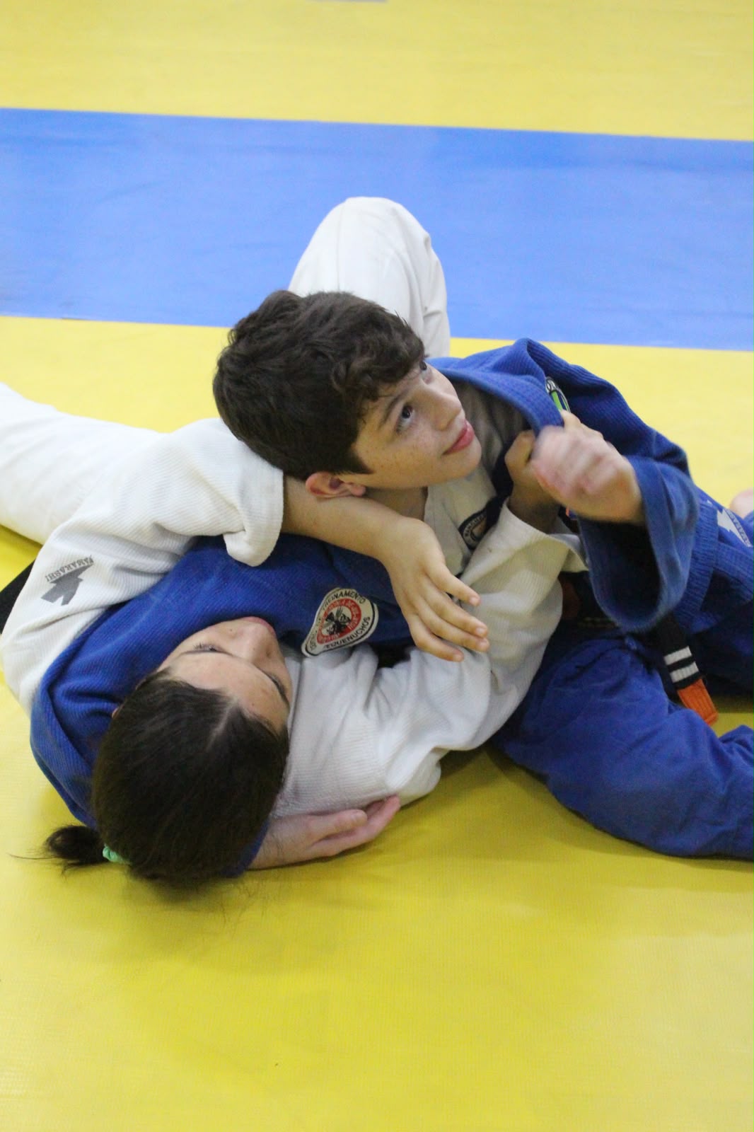 Alunos da Pequenuchos praticando Jiu-Jitsu no tatame